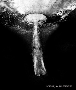 Diver entering the water from a high dive.  She hit the w... by Ken Kiefer 